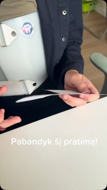 Vaikas kerpa popierių žirklėmis